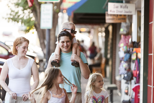 Family walking together on a sunny day in downtown Branson, MO, enjoying local shops and family-friendly atmosphere