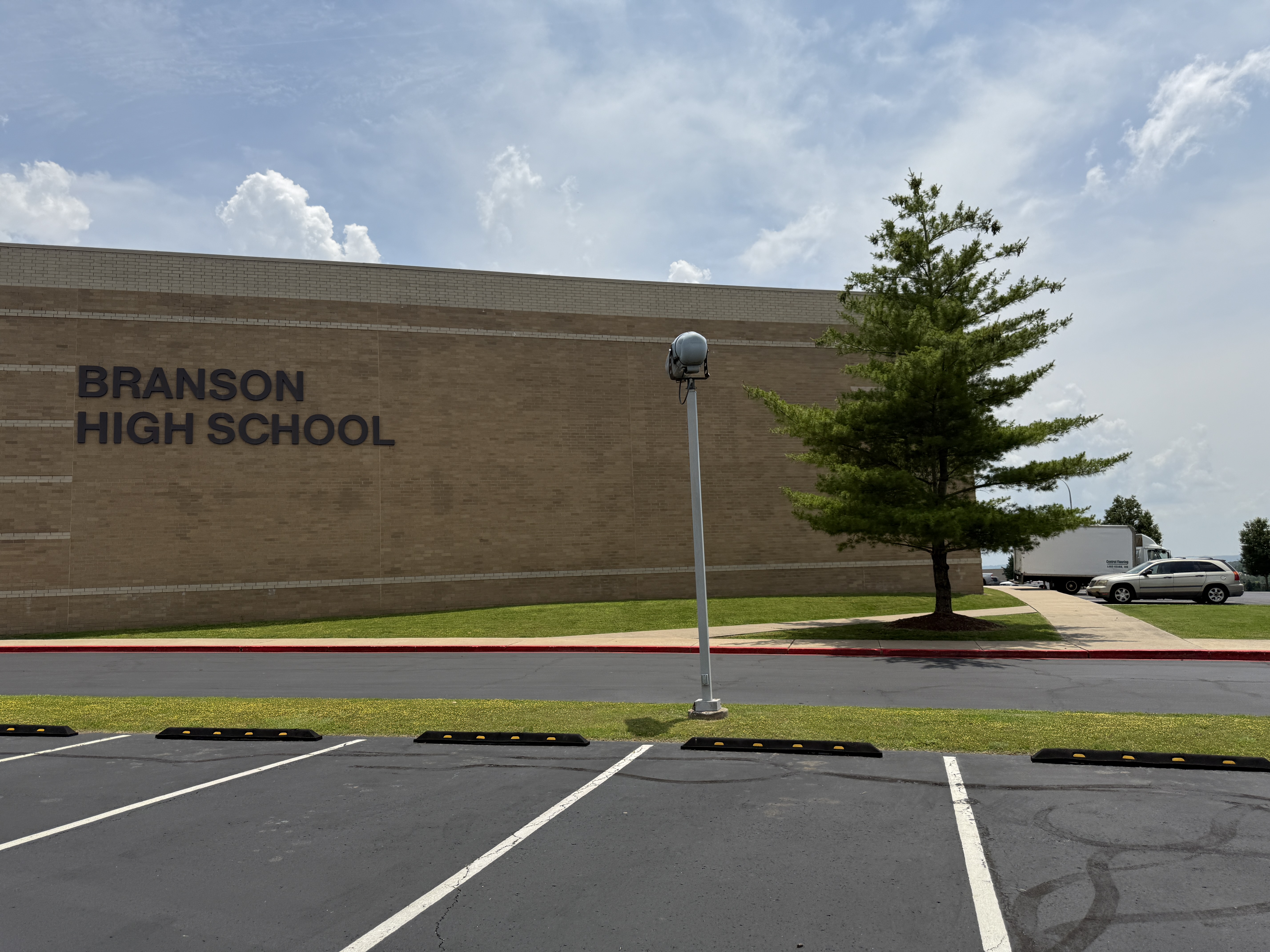 Exterior view of Branson High School building in Branson, MO with parking lot in foreground