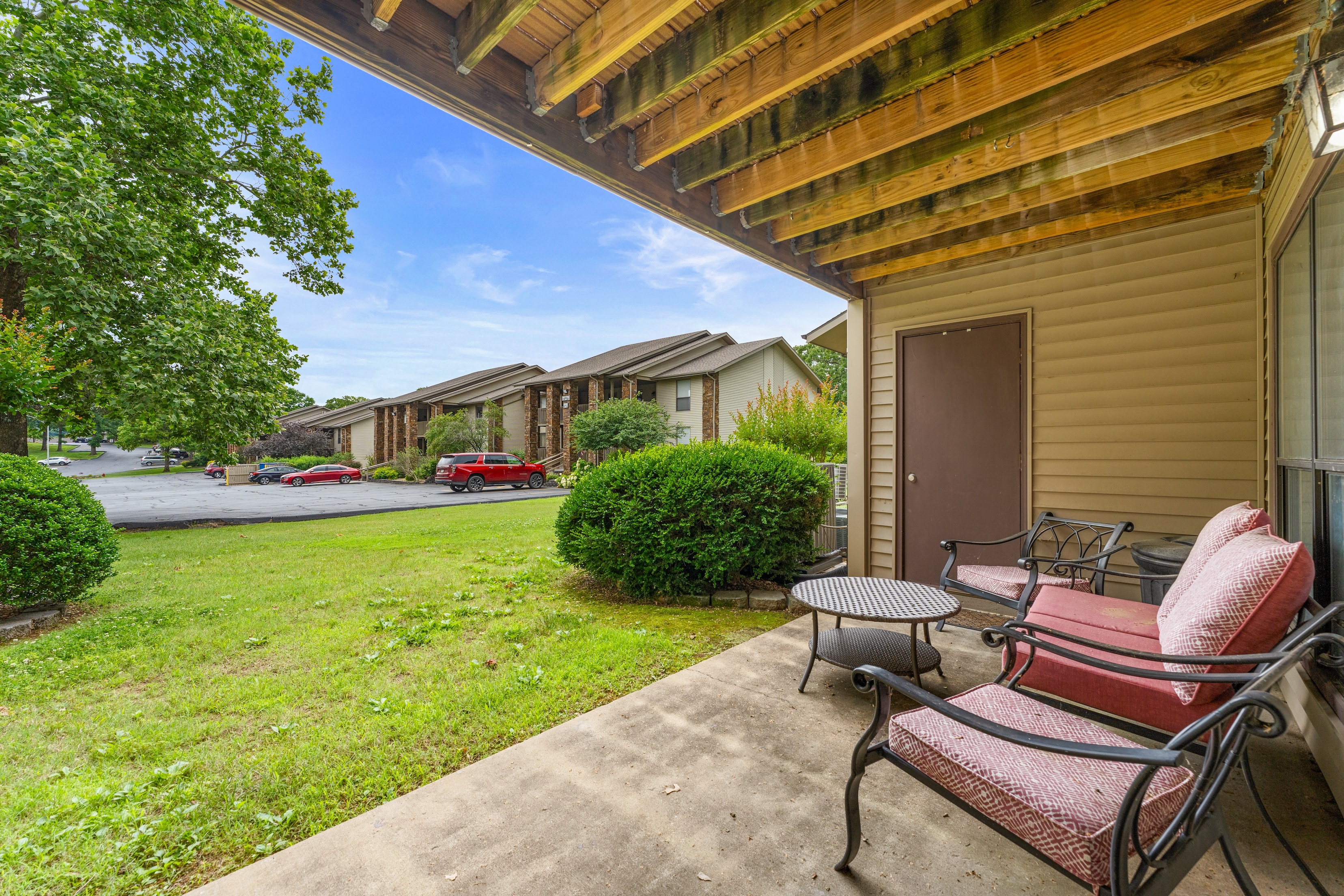 Covered patio with outdoor seating overlooking lawn and nearby condo buildings in Branson, Missouri.