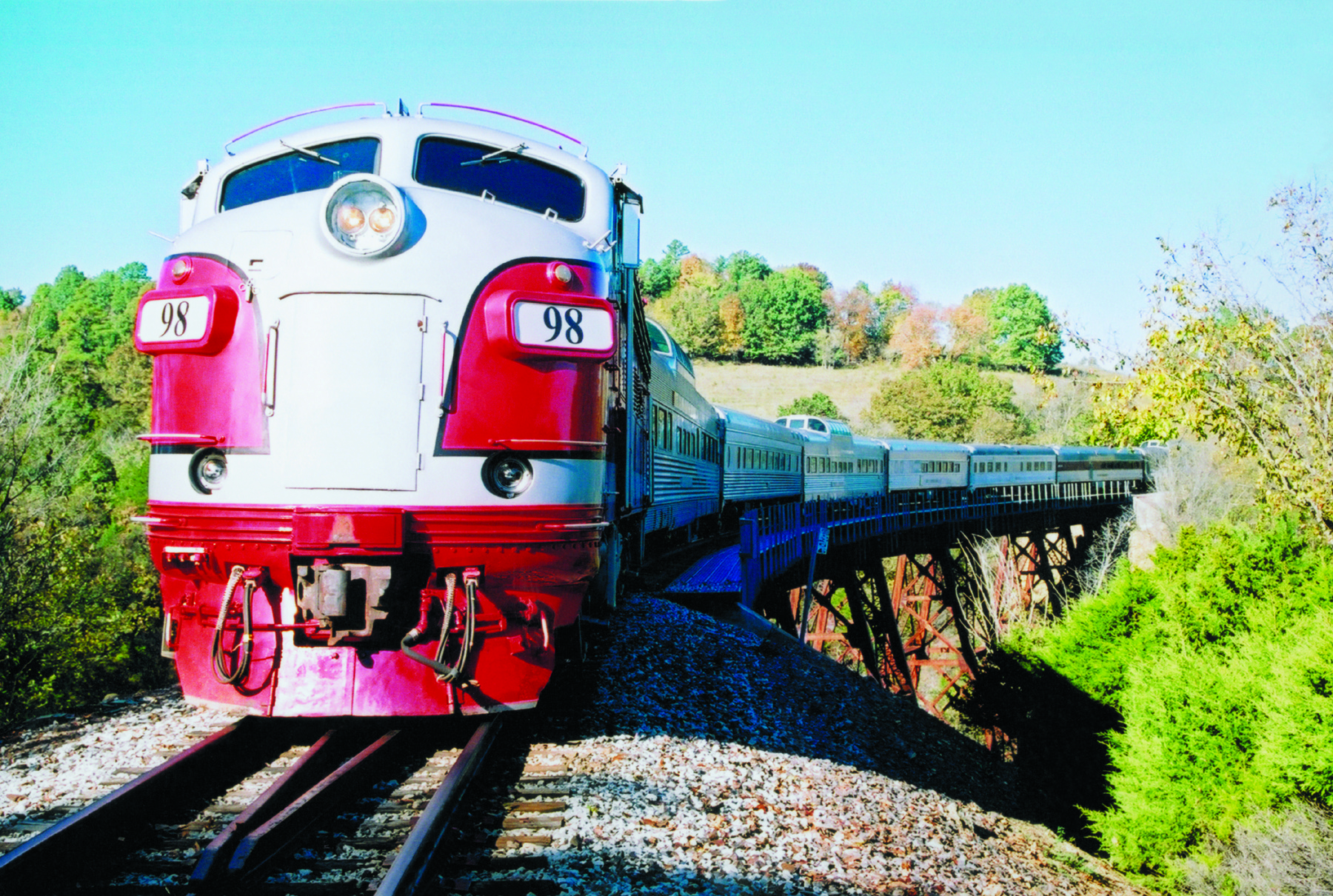 Branson Scenic Railway train crossing a trestle bridge through the Ozark hills near Branson Missouri