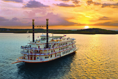 Branson Showboat Belle paddlewheel boat cruising on Table Rock Lake at sunset with Ozark hills in the background